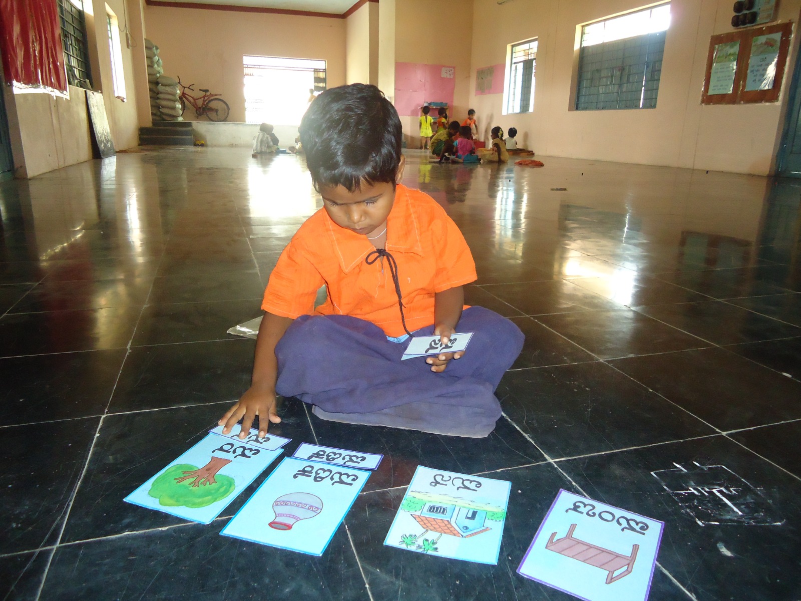 Child engaged in a learning activity with educational picture cards